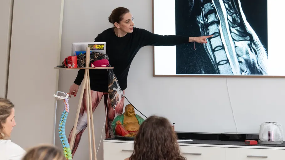 Woman pointing at spinal image during presentation.