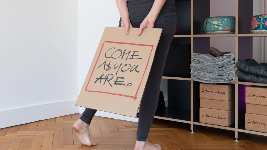 Person holding sign in yoga studio.