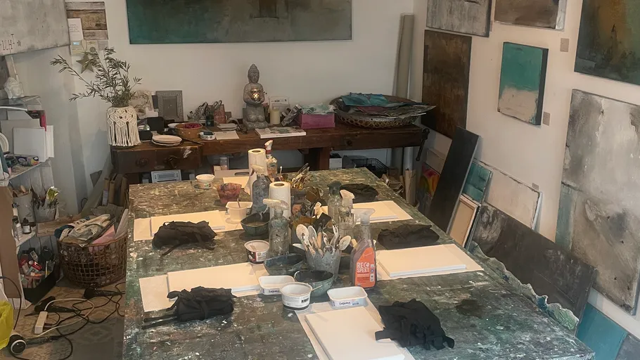 Art studio setup with painting supplies on table.