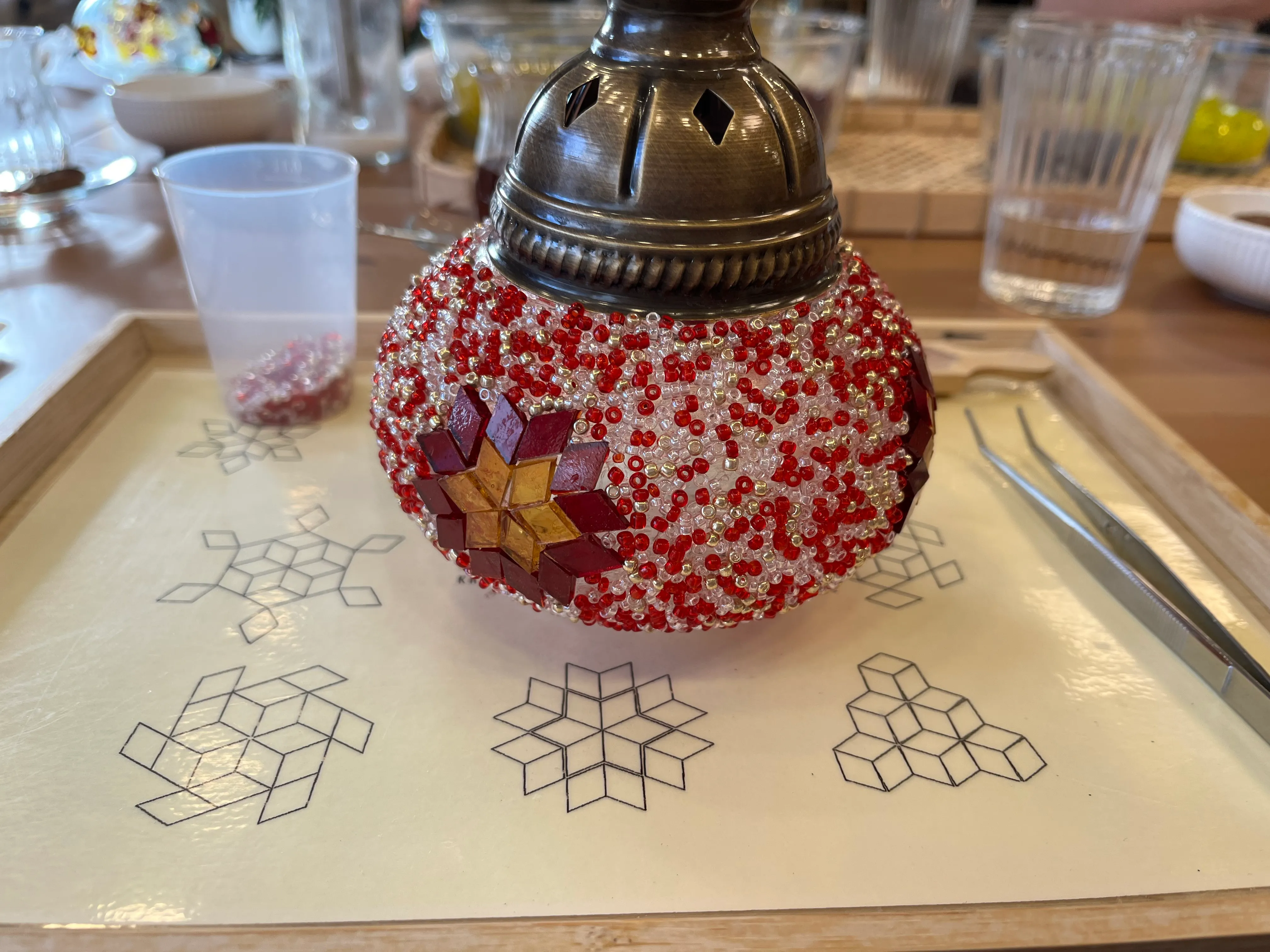 Perlenverzierte Kugel auf Tisch mit Werkzeugen.