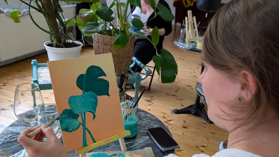 Person painting plant in indoor studio setting.