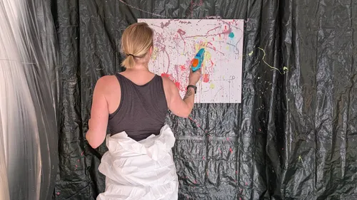 Person painting with water gun indoors.
