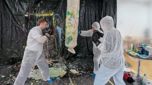 Drei Personen boxen auf bemalten Sandsack innen.