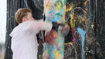 Man boxing painted pillar indoors.