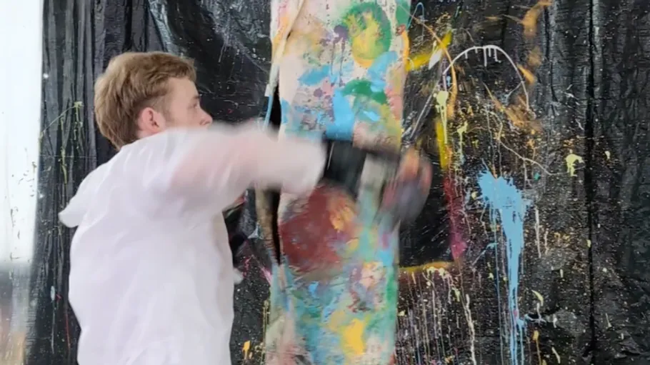 Man boxing painted pillar indoors.