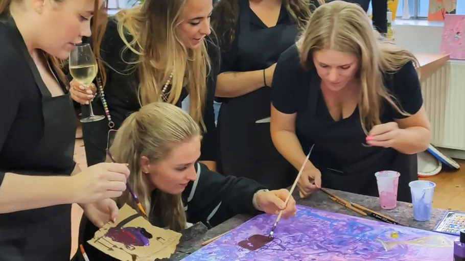 Women painting together at a table.