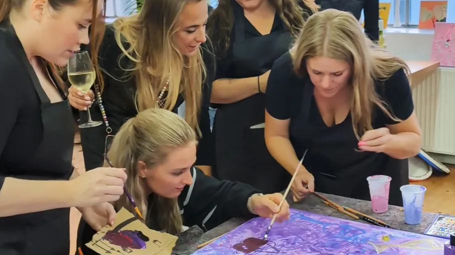 Group of women painting art together indoors.