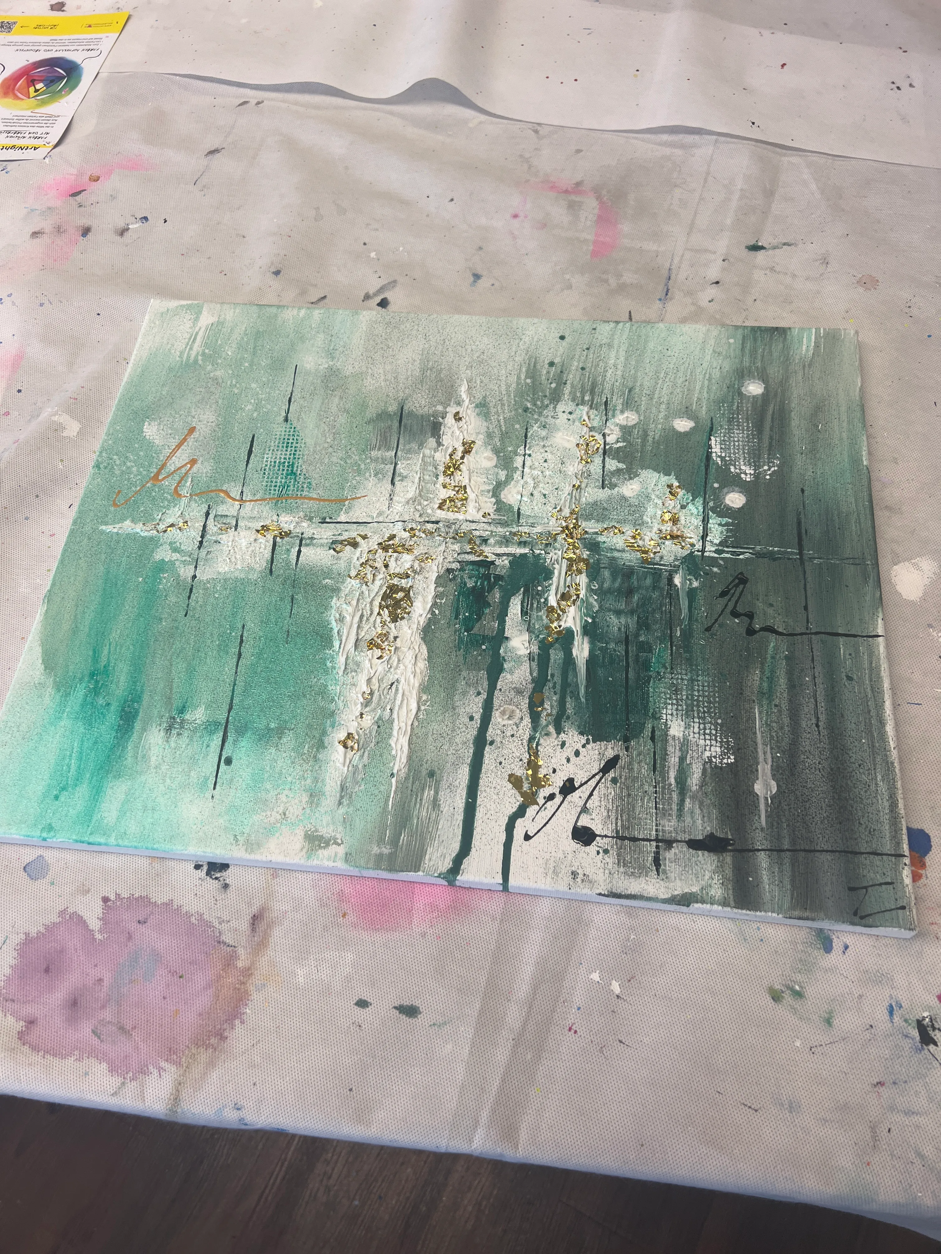 Abstraktes Gemälde auf Tisch mit Farbklecksen.