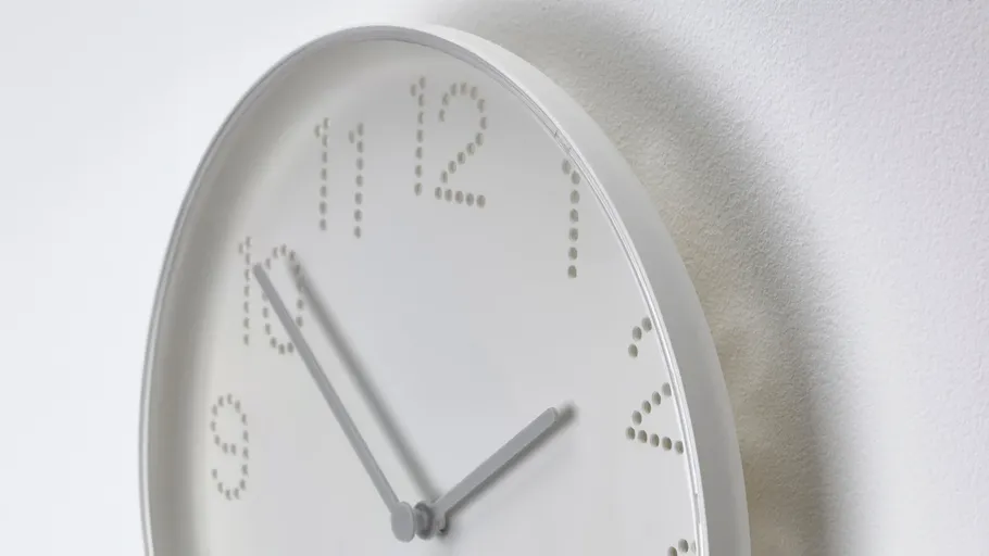 Minimalist clock with dotted numbers on wall.