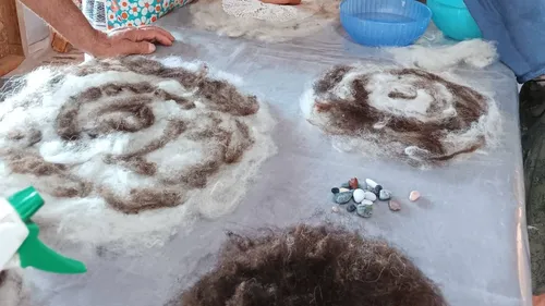 Hand crafting felt patterns on table.