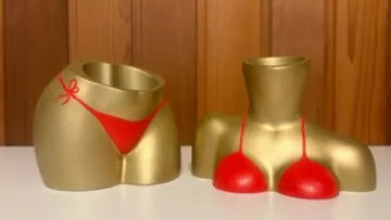 Goldene Körpervasen in roten Badeanzügen auf Tisch.