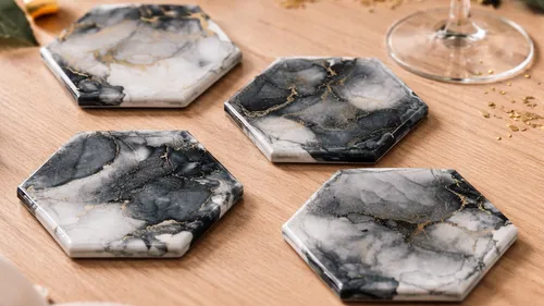 Hexagonal marble coasters arranged on wooden table.