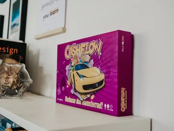 Spielebox steht auf einem Regal, bunt und auffällig.
