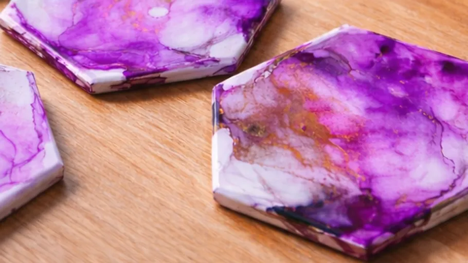Purple marbled coasters on a wooden table.