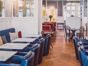 Café with tables, empty chairs and an elegant setting.