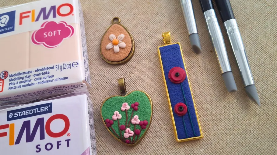 Polymer clay and tools with decorated pendants.