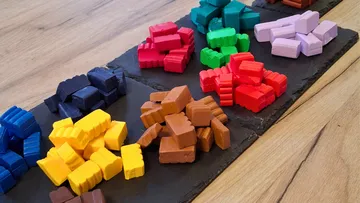 Colorful game pieces on wooden background.