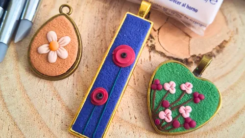 Drei Polymer-Clay-Anhänger mit Blumenmotiven.