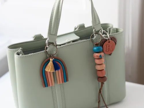 Grüne Handtasche mit bunten Anhängern drinnen.