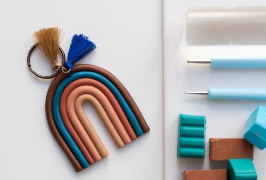 Colorful rainbow keychain beside crafting tools.