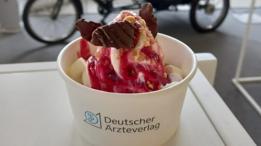 Ice cream with toppings in a branded cup.