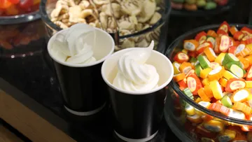 Zwei Becher mit Eiscreme und Süßigkeiten.