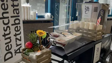 Frozen yogurt cart with toppings and decorations indoors.