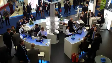 People socializing at a busy conference bar.