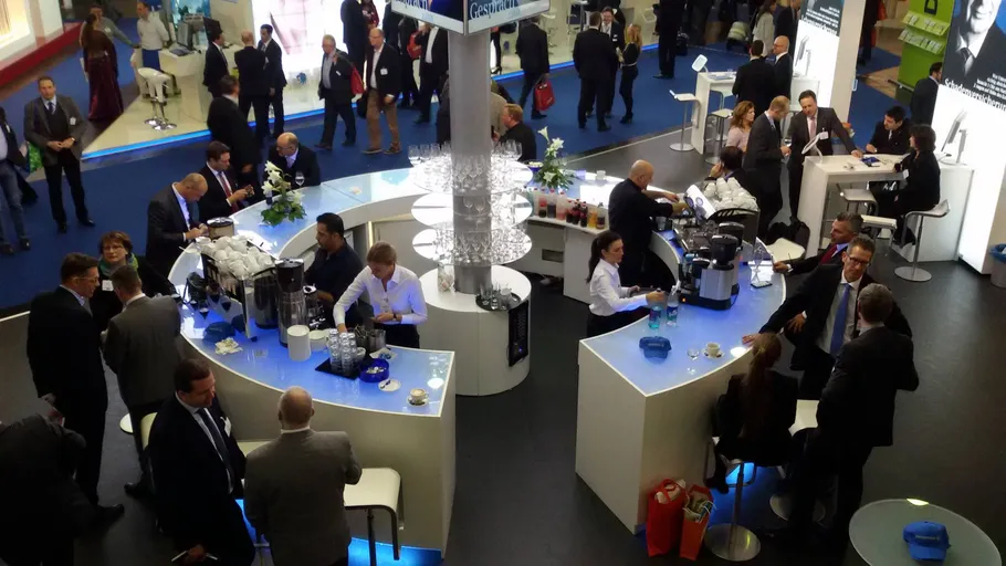 People socializing at a busy conference bar.