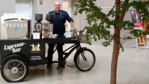 Mann serviert Kaffee von mobiler Espresso-Bar innen.