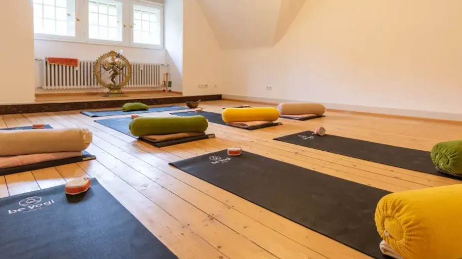 Yoga mats with cushions in a spacious room.