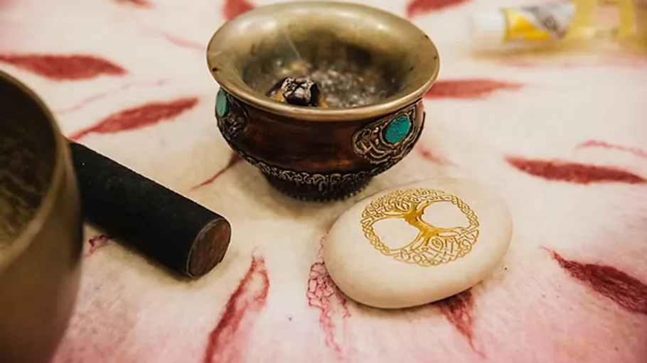 Decorative bowl and stone on patterned cloth.