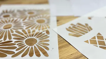 Papier-Schablonen mit Blumen- und geometrischen Mustern.