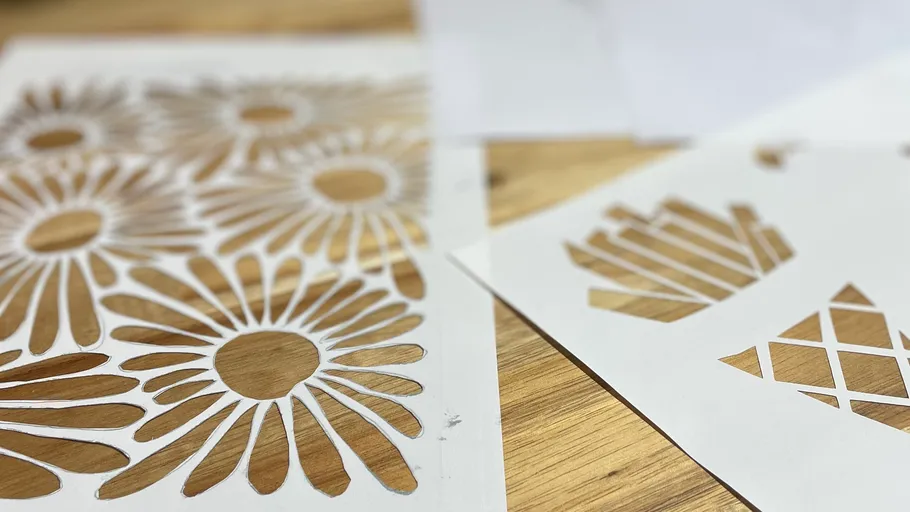 Papier-Schablonen mit Blumen- und geometrischen Mustern.