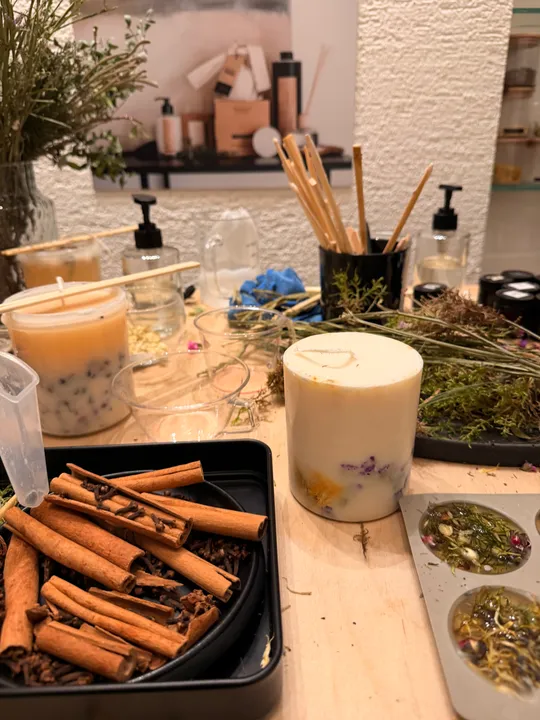 Kerzenmaterialien mit Kräutern und Zimt.