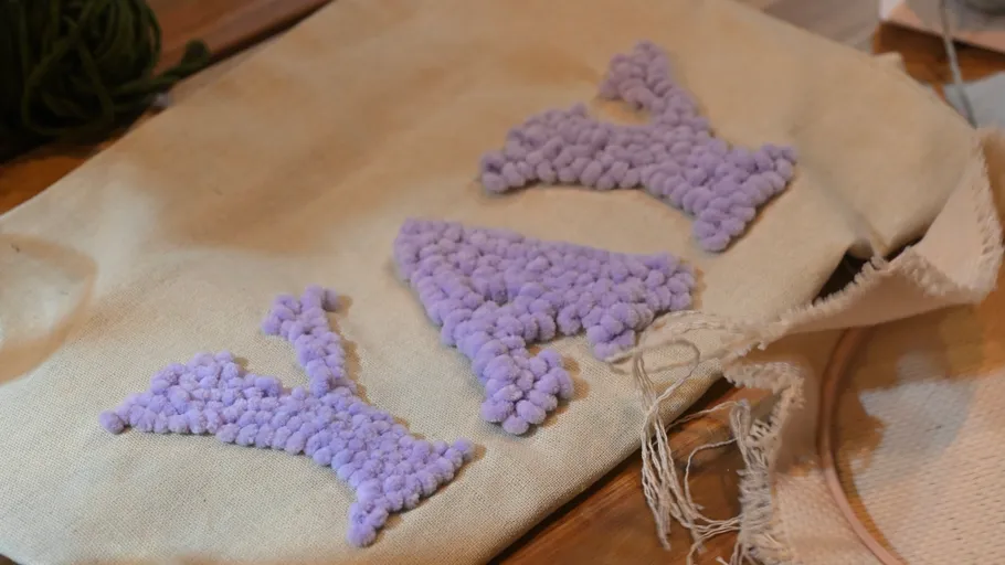 Purple textured letters on cloth surface.
