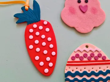 Drei bunte Tonornamente auf einer Oberfläche.