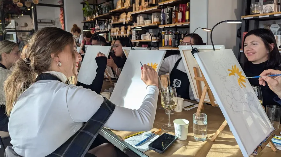 People painting on canvases in a cafe.