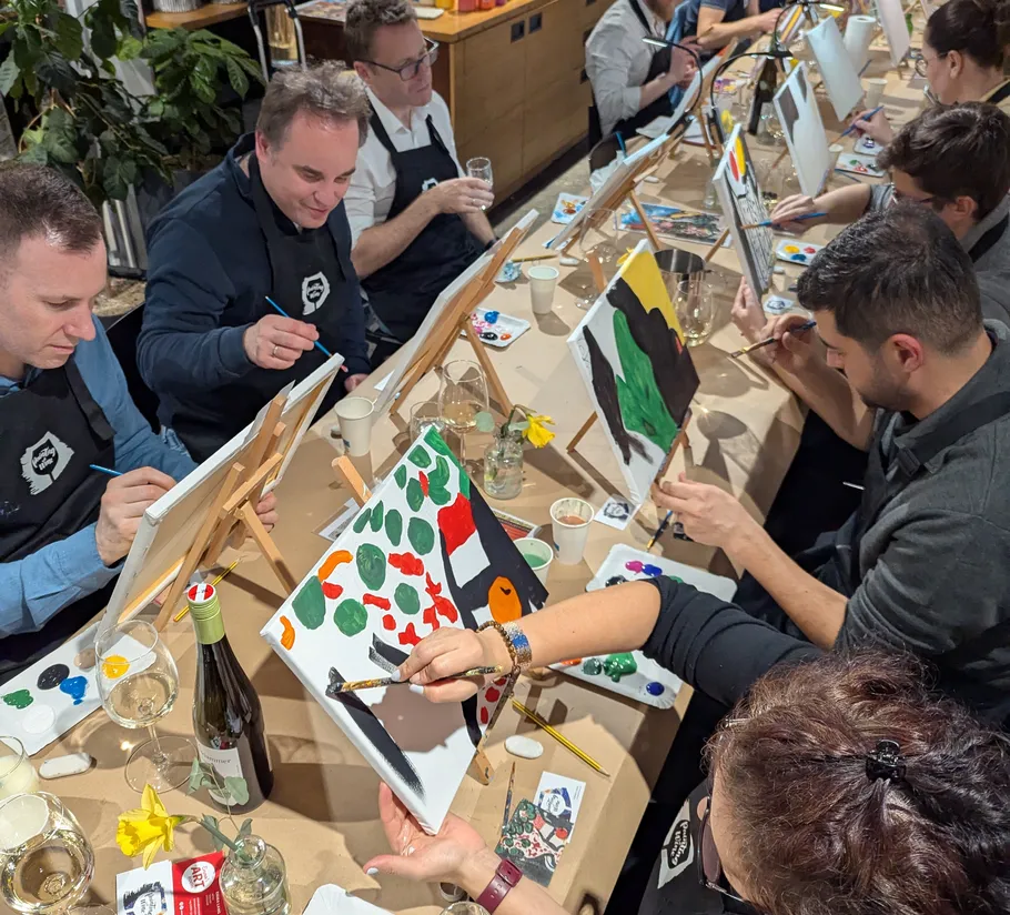People painting at a table in an art workshop.
