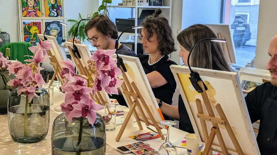 People painting at easels in a studio.
