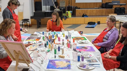 People painting at a table indoors.