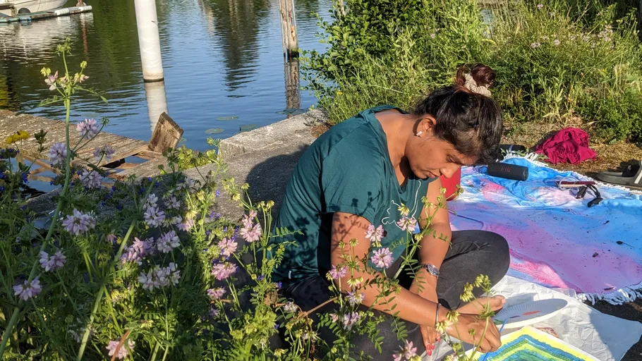 Person painting outdoors by a lake.