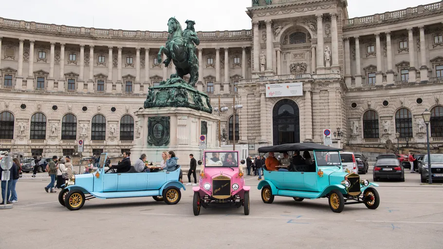Vintage cars parked in front of historic building.