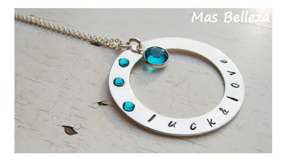 Silberne Halskette mit blauen Steinen auf Tisch.