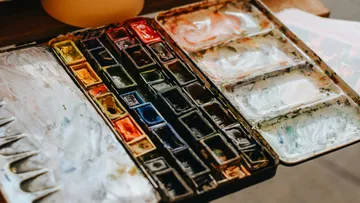Offene Aquarellpalette auf Holztisch.