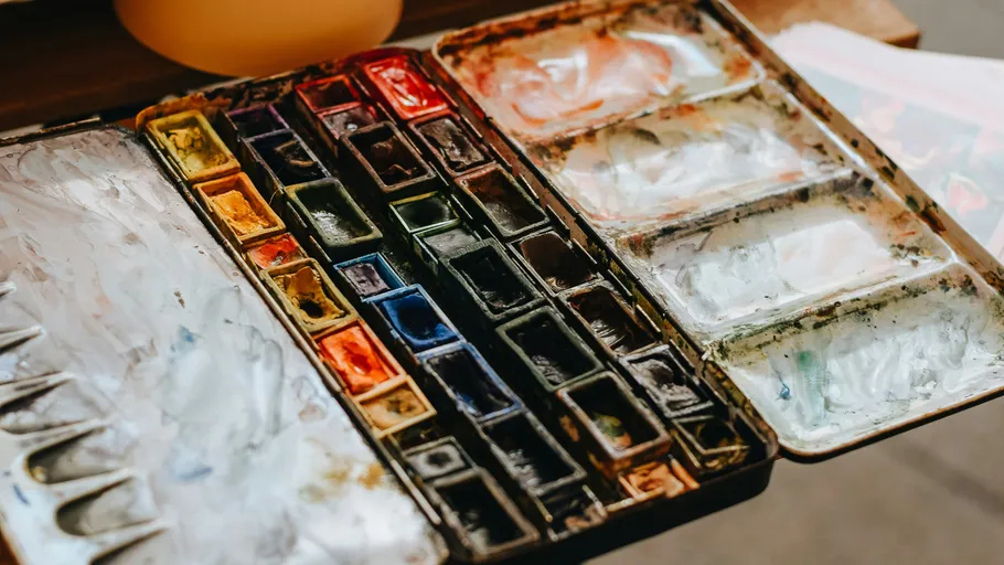Open watercolor palette on wooden table.