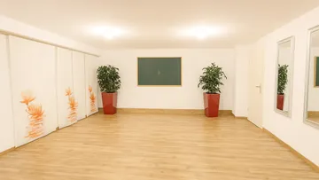 Empty room with plants and large mirrors.