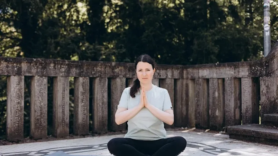 Woman meditating outdoors on a sunny day.
