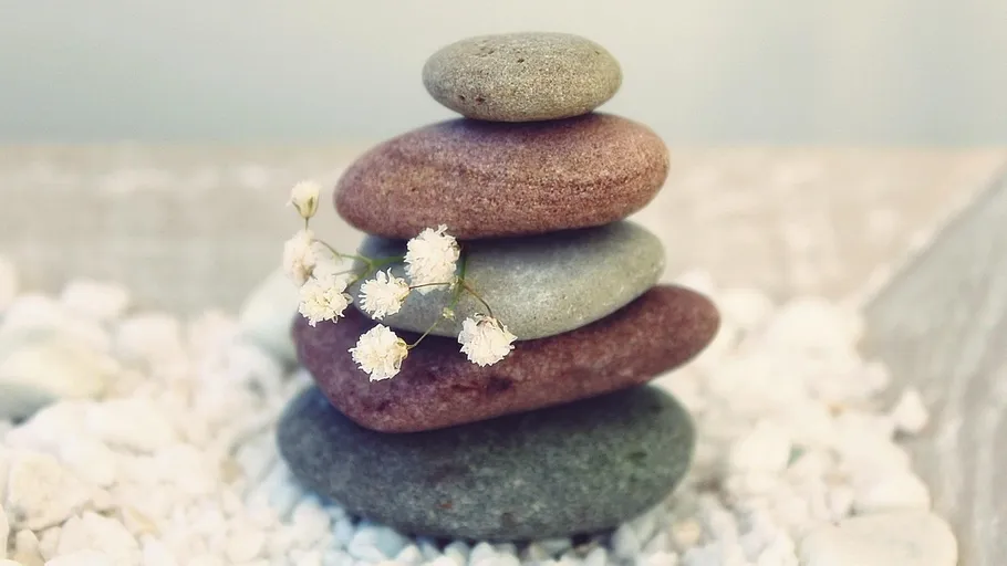 Stacked stones with small white flowers.