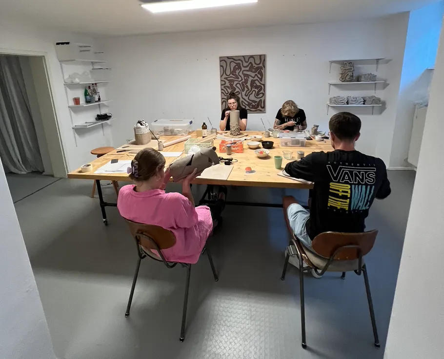 Vier Personen arbeiten an einem großen Tisch.